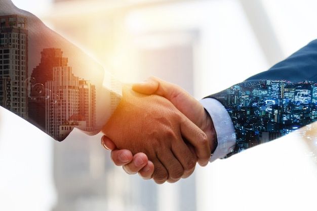 Investment opportunity handshake with cityscape